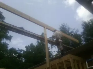 Carpenter setting a ridge beam over a new addition frame — Ice Dam Removal by Roofing Brothers in Gypsum