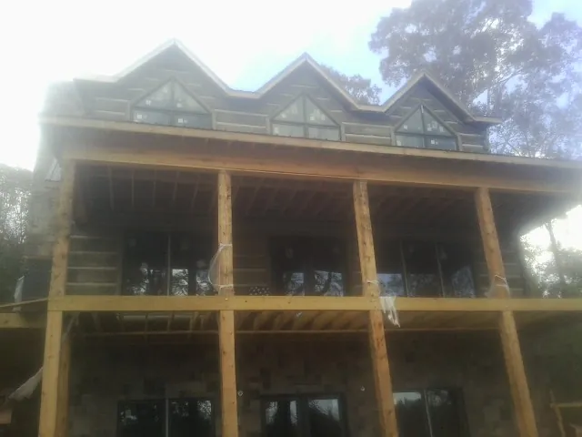 Dormers and porch framing on a large log home under construction — Roof Coating work by our crew in Gypsum