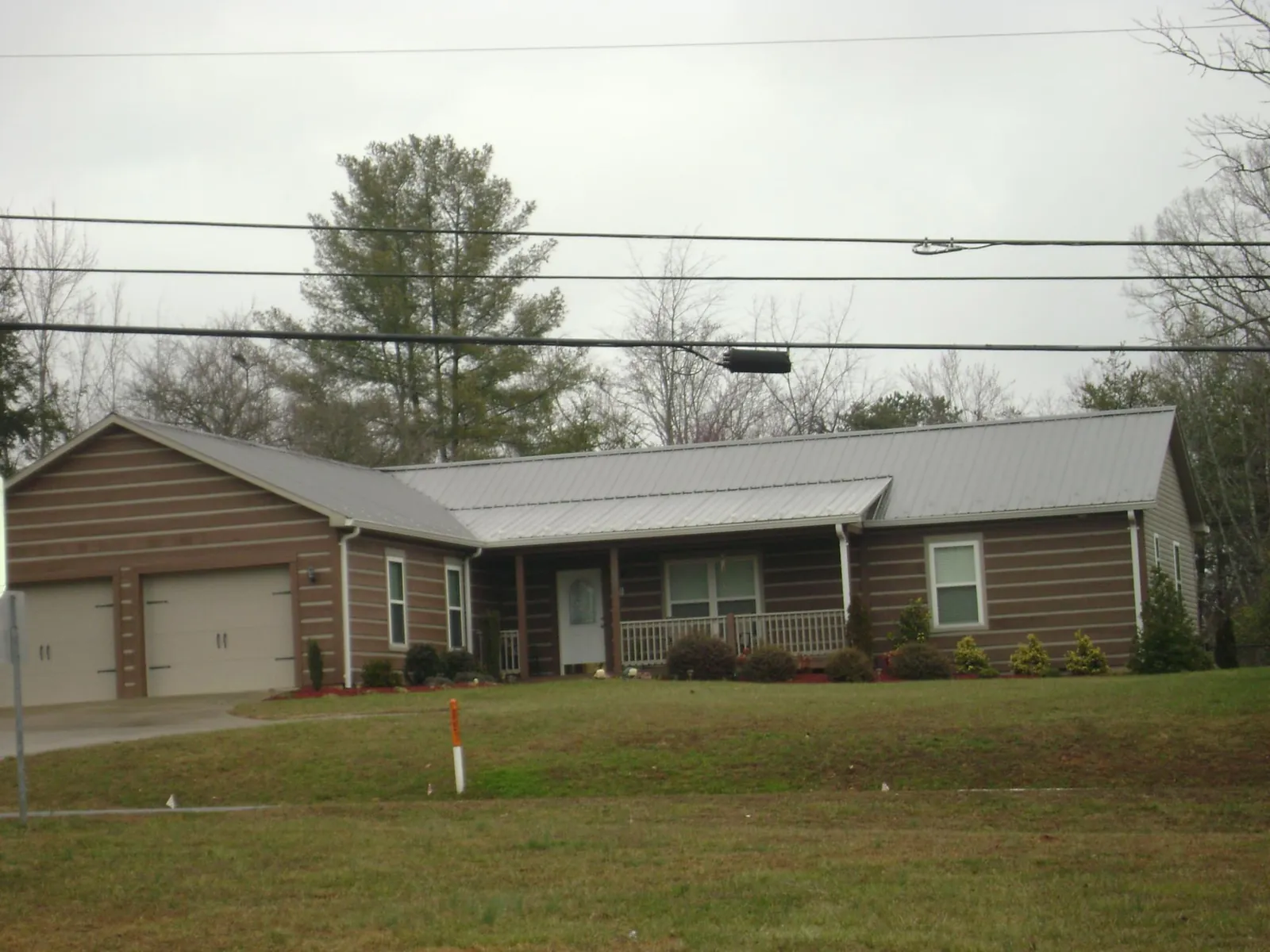 Gray metal roof on a log sided ranch home with a front porch in Gypsum